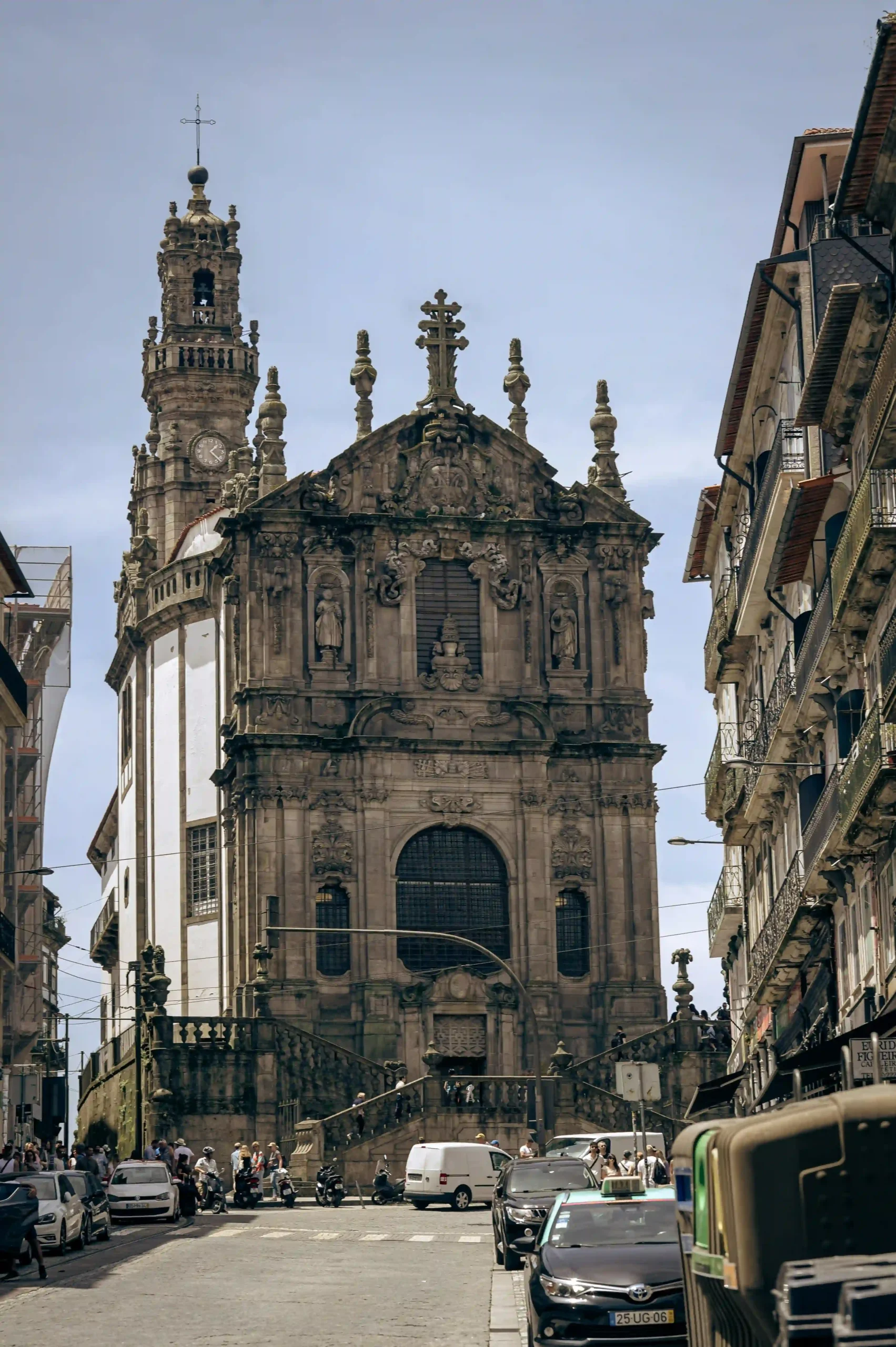 The ornate Baroque facade of the Clérigos Church on a historic street in Porto, Portugal.