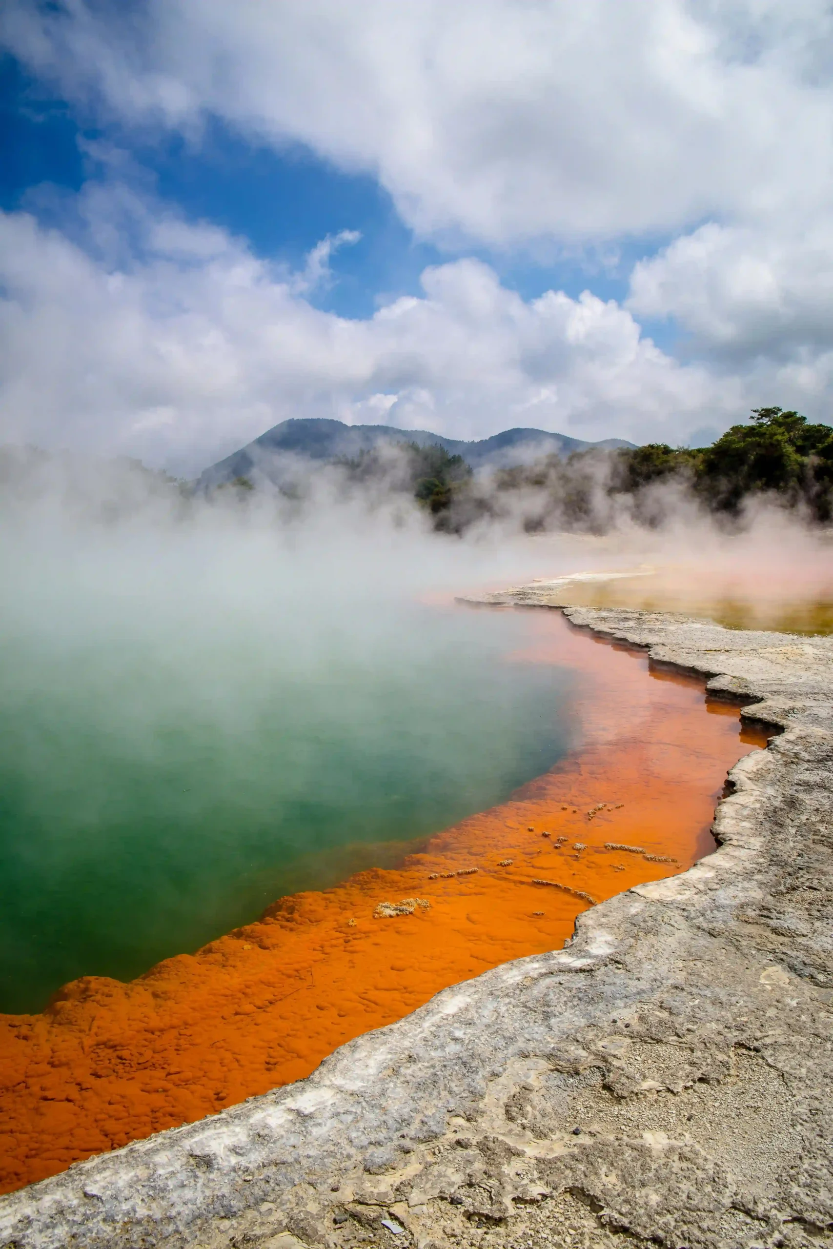 The vibrant orange and green colors of a geothermal spring in New Zealand.