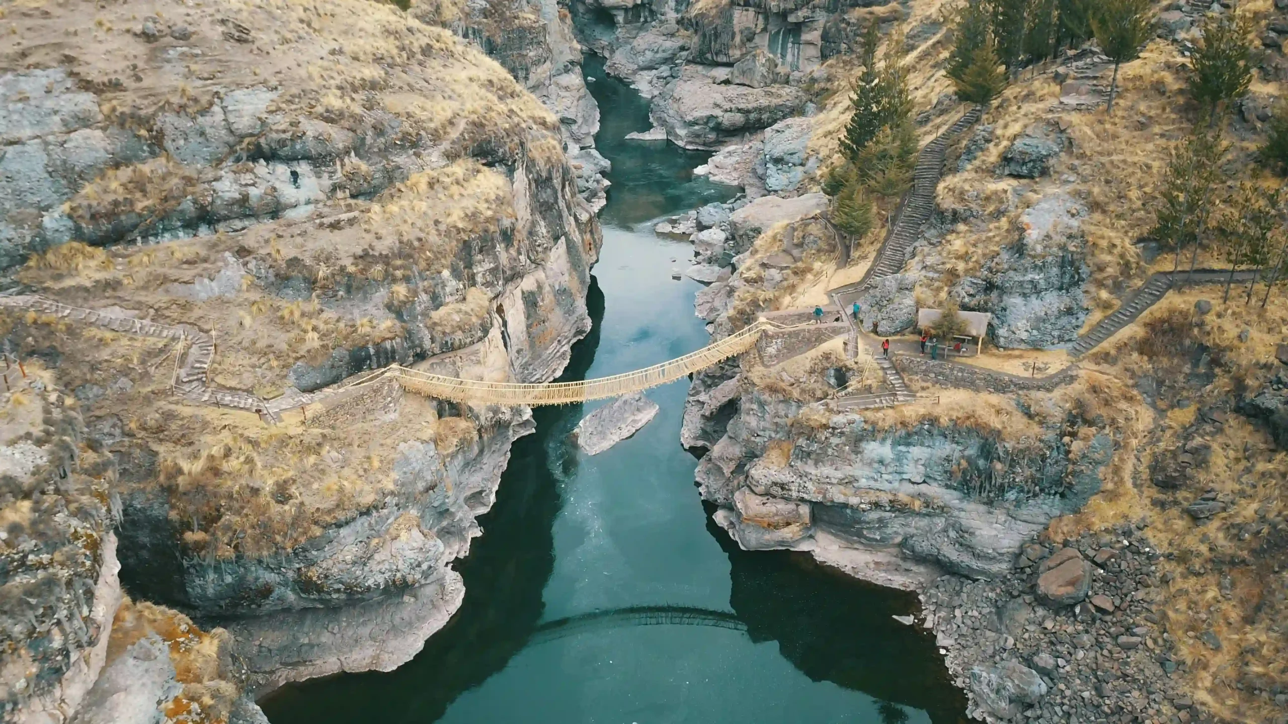 The last handwoven Inca rope bridge, Q'eswachaka, suspended across a deep, rocky canyon in the Peruvian Andes.