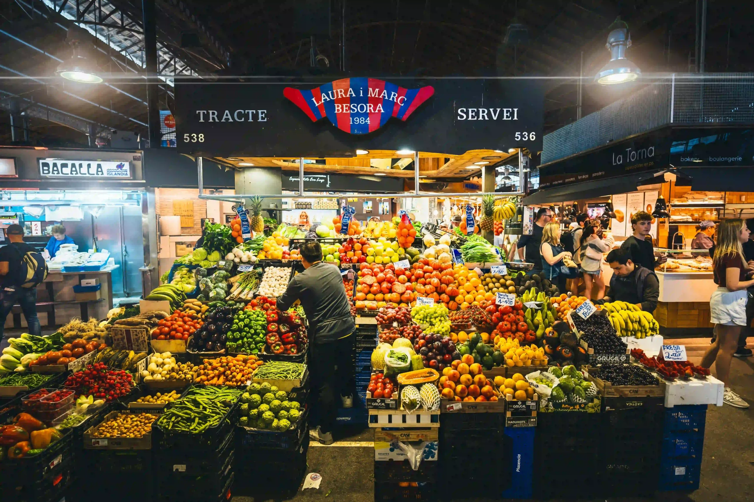 A bustling, traditional food market in Barcelona filled with fresh produce.