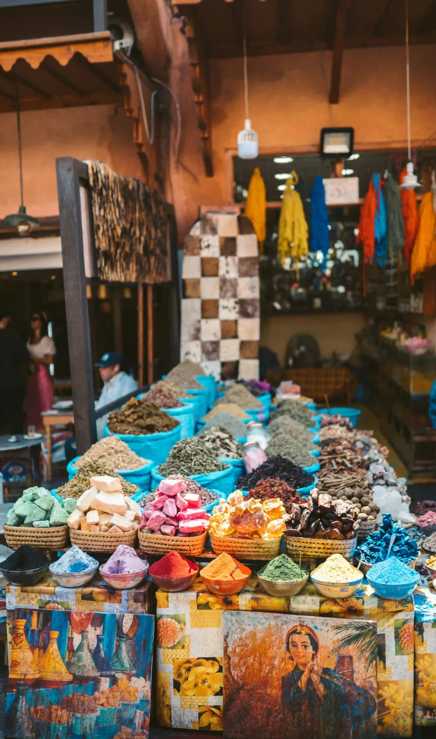 Colorful spices and tagine pots arranged in a bustling Moroccan souk.